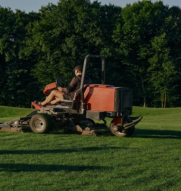 person riding lawn mower