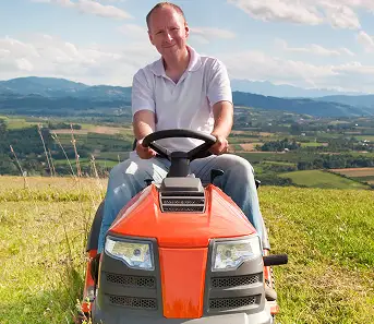 man driving lawnmower